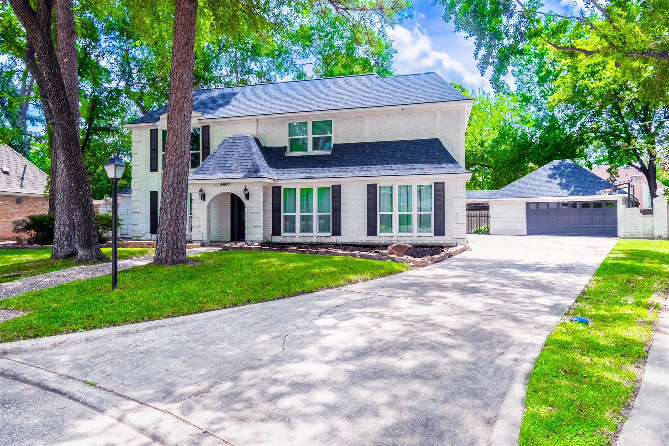 a front view of a house with a yard and trees