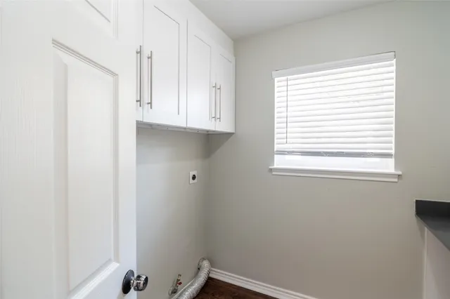 a room with a window and a white cabinet