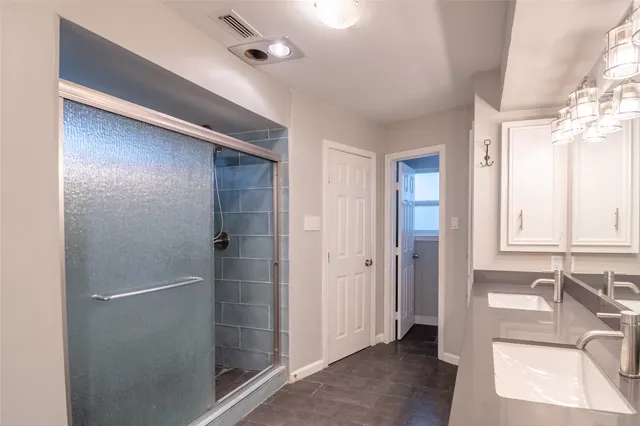 a bathroom with double sink and a mirror