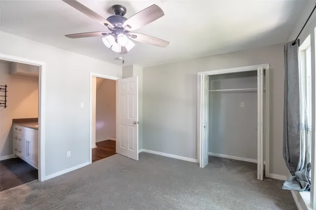 a bathroom with a granite countertop sink a toilet and shower