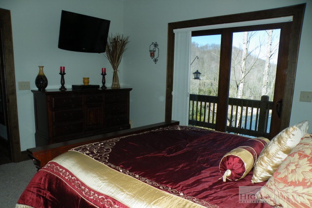 1459 Pine Ridge Road Beech Mountain, NC 28604 - Photo 22 of 25 a bedroom with a bed closet and flat tv screen