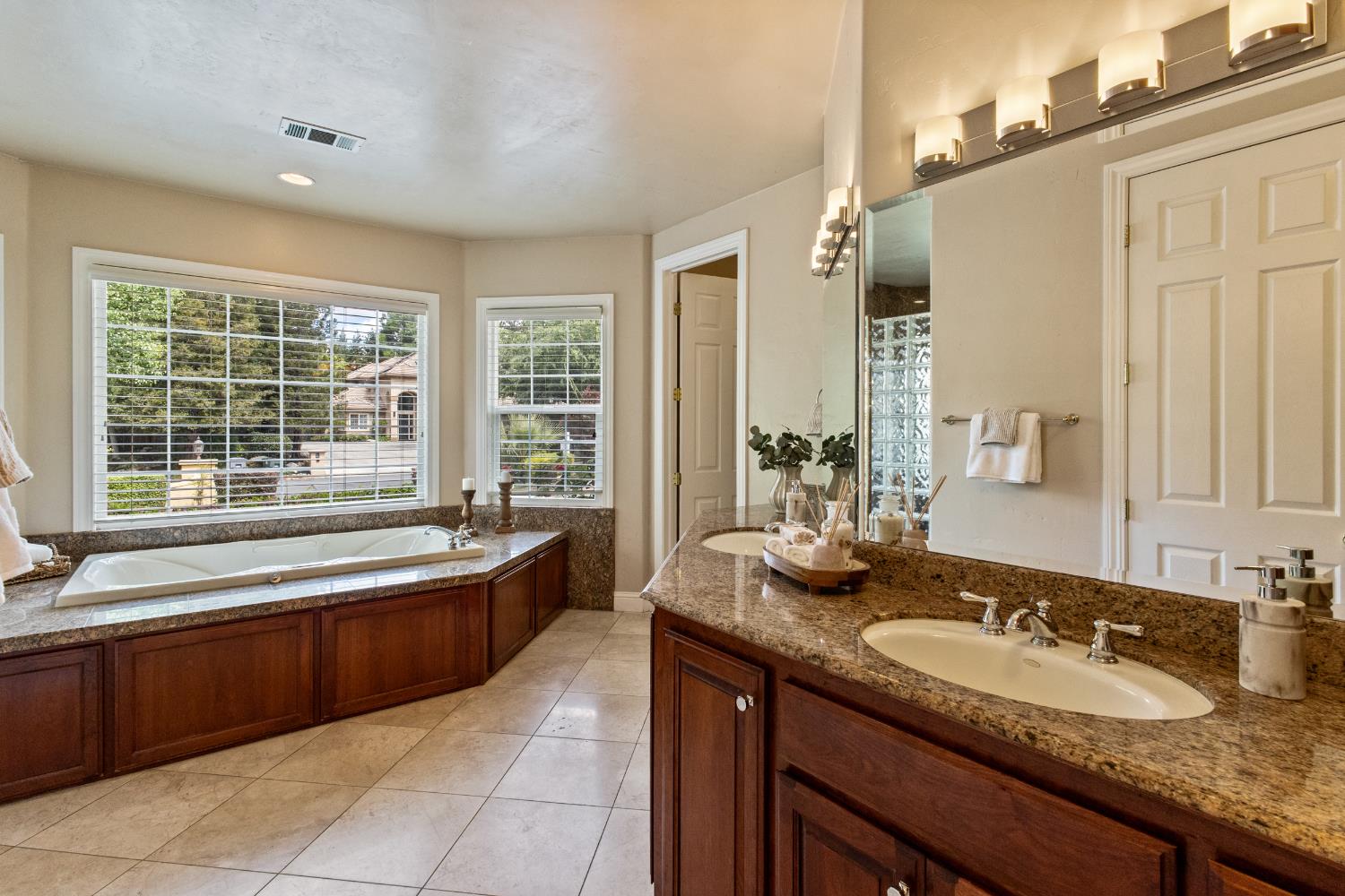 9003 Cedar Ridge Drive Granite Bay, CA 95746 - Photo 19 of 65 a bathroom with a granite countertop bathtub sink and mirror