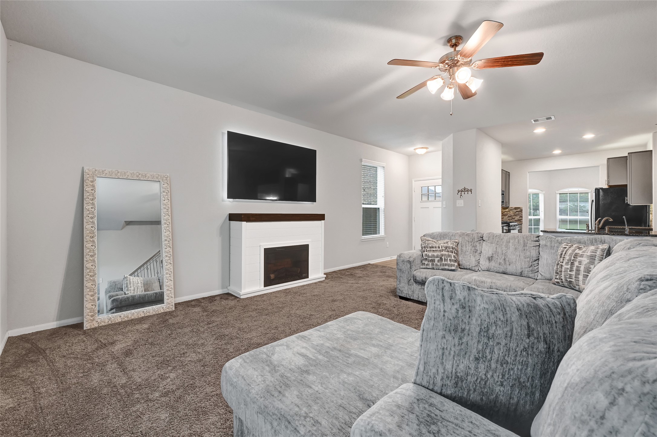 11346 Cascading Stream Way Houston, TX 77044 - Photo 6 of 24 a living room with furniture a fireplace and a flat screen tv