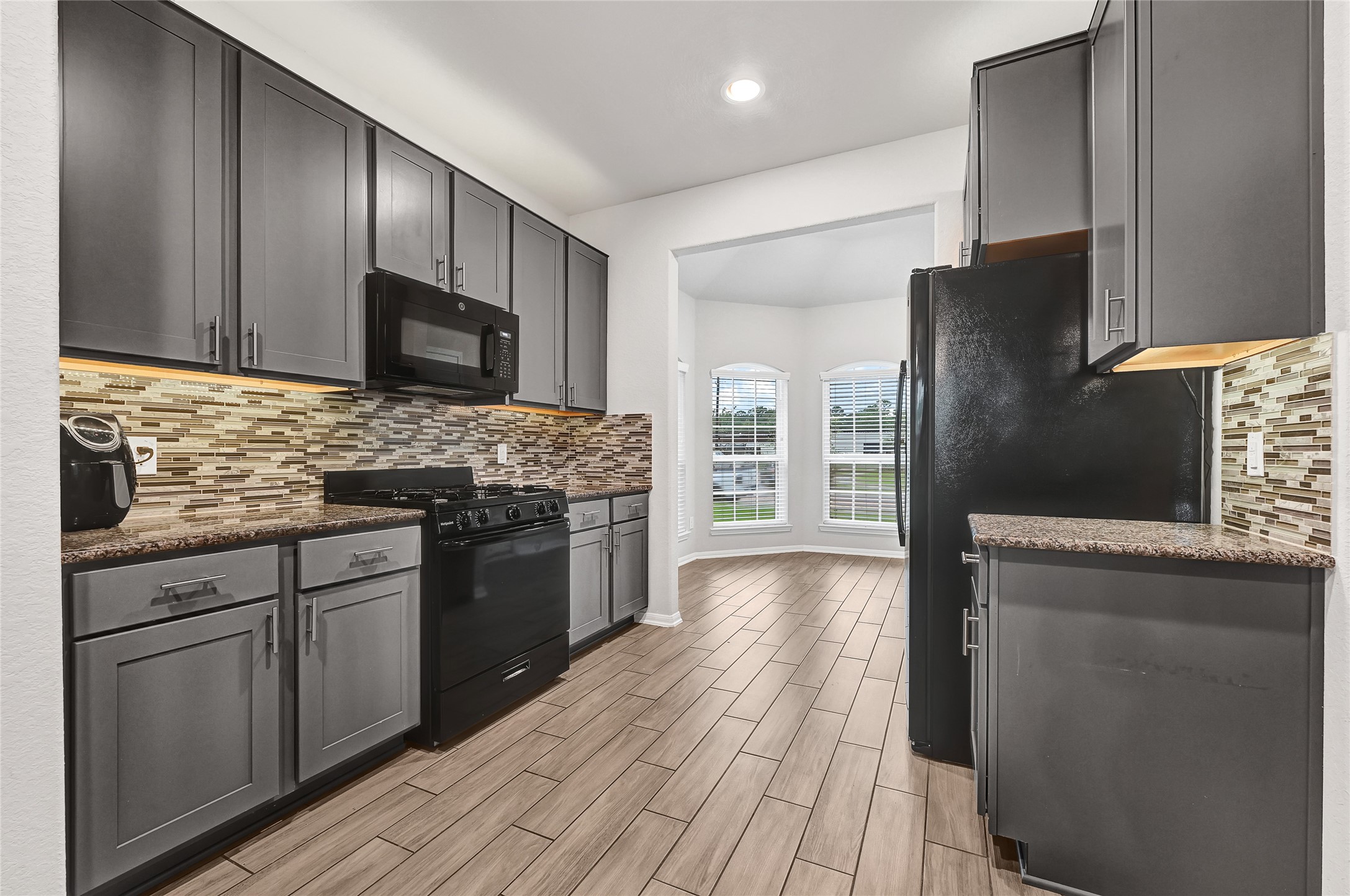 11346 Cascading Stream Way Houston, TX 77044 - Photo 10 of 24 a kitchen with stainless steel appliances granite countertop a refrigerator stove microwave and sink