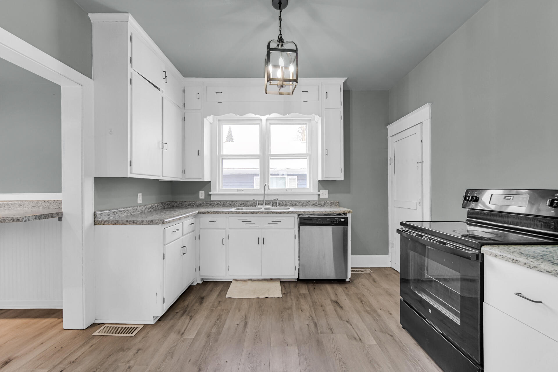 404 F Street La Porte, IN 46350 - Photo 16 of 35 a kitchen with granite countertop white cabinets white stainless steel appliances and wooden floor