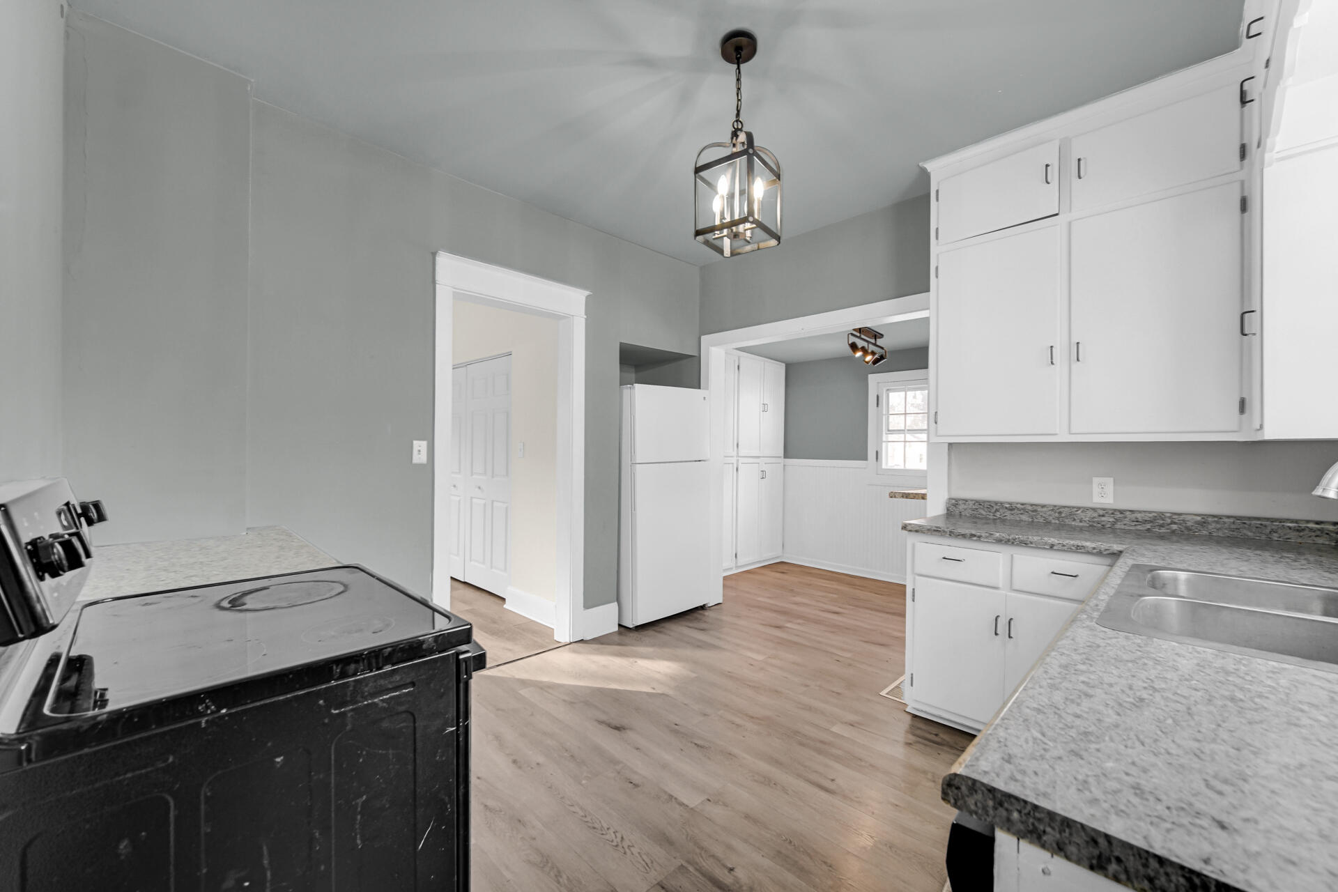 404 F Street La Porte, IN 46350 - Photo 20 of 35 a kitchen with granite countertop white cabinets and wooden floor