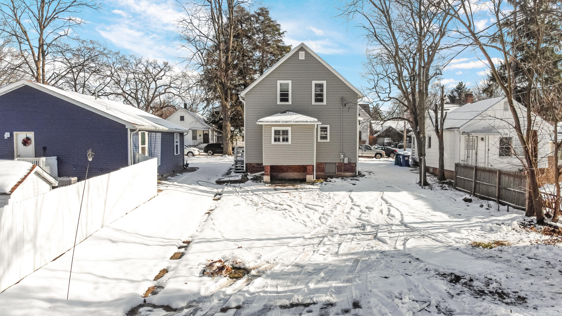 404 F Street La Porte, IN 46350 - Photo 6 of 35 a view of a white house with a yard covered in snow