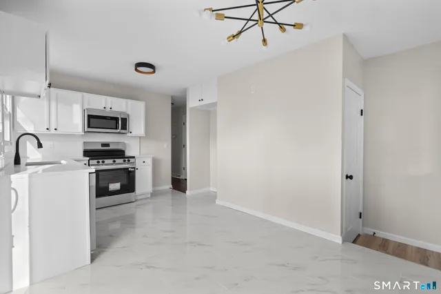 a kitchen with granite countertop a refrigerator and a stove top oven