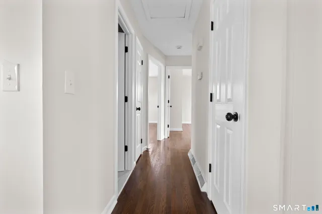 a view of a hallway with wooden floor