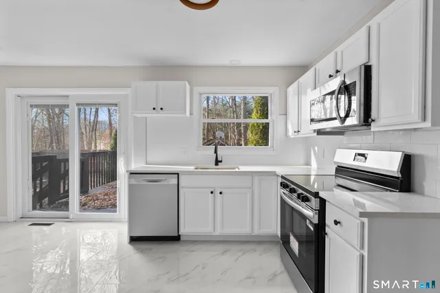a kitchen with granite countertop a sink stove and cabinets