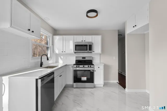 a kitchen with a sink stove and microwave