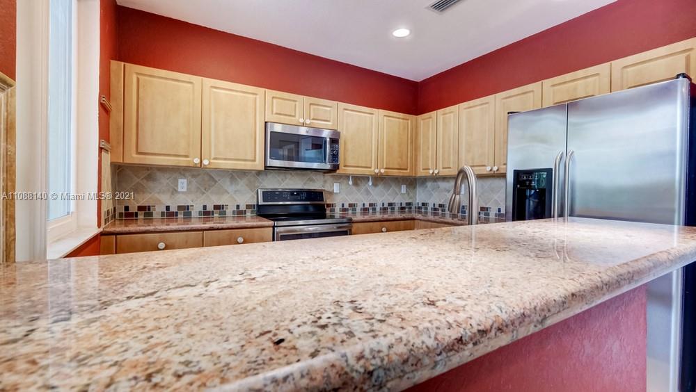 1311 Southeast 20th Road, Unit 1311 Homestead, FL 33035 - Photo 13 of 40 a kitchen with stainless steel appliances granite countertop a stove a sink and a microwave