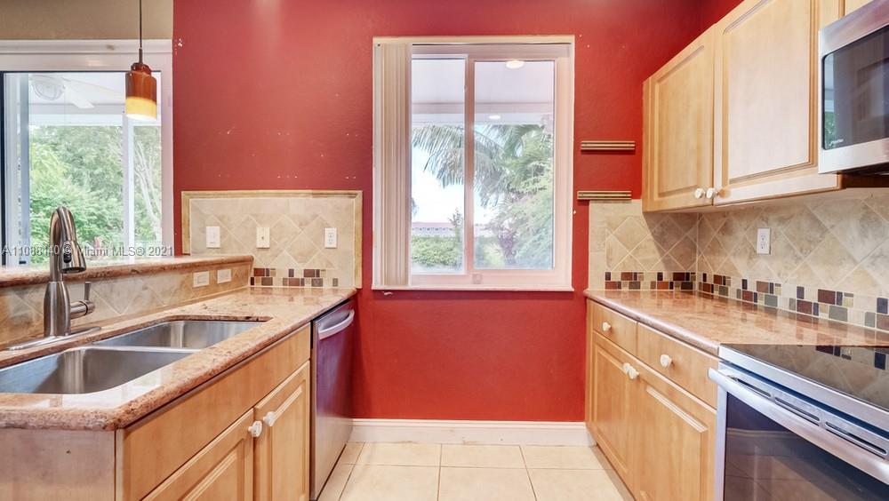 1311 Southeast 20th Road, Unit 1311 Homestead, FL 33035 - Photo 16 of 40 a kitchen with granite countertop a sink and a window