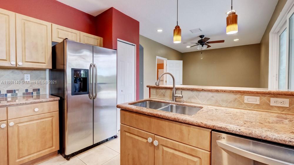 1311 Southeast 20th Road, Unit 1311 Homestead, FL 33035 - Photo 17 of 40 a kitchen with stainless steel appliances granite countertop a sink a refrigerator and cabinets