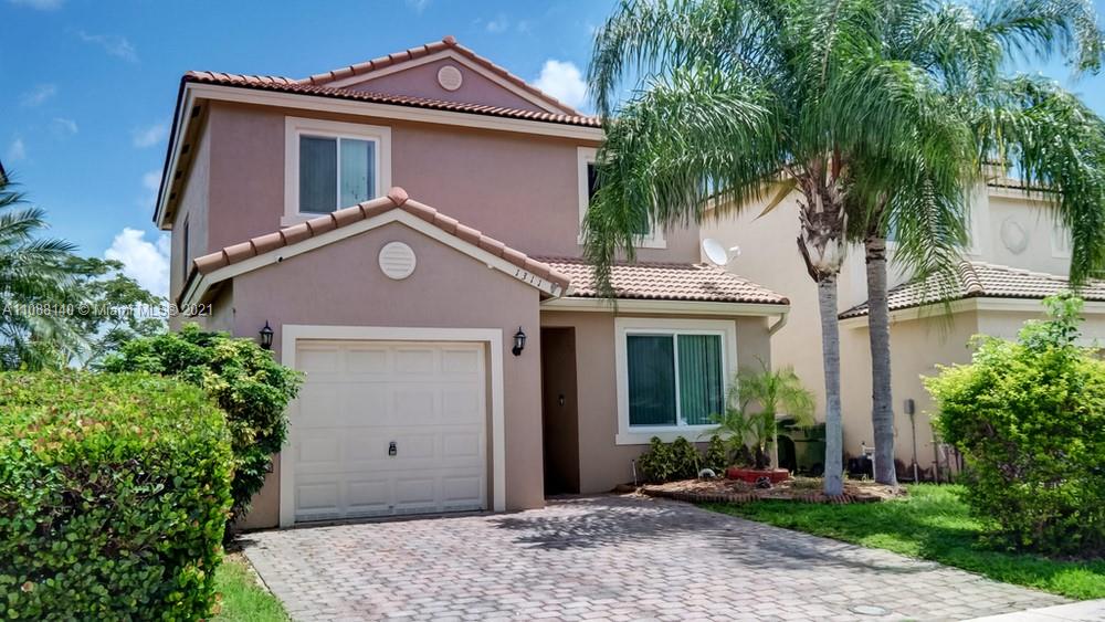1311 Southeast 20th Road, Unit 1311 Homestead, FL 33035 - Photo 2 of 40 a front view of a house with a garden