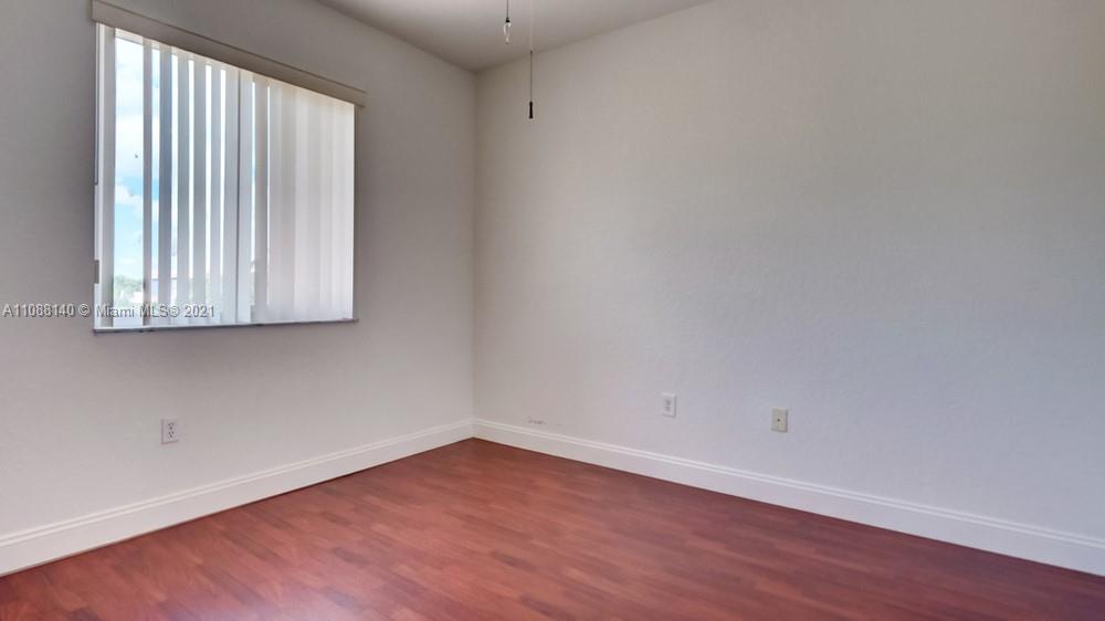 1311 Southeast 20th Road, Unit 1311 Homestead, FL 33035 - Photo 35 of 40 an empty room with wooden floor and windows