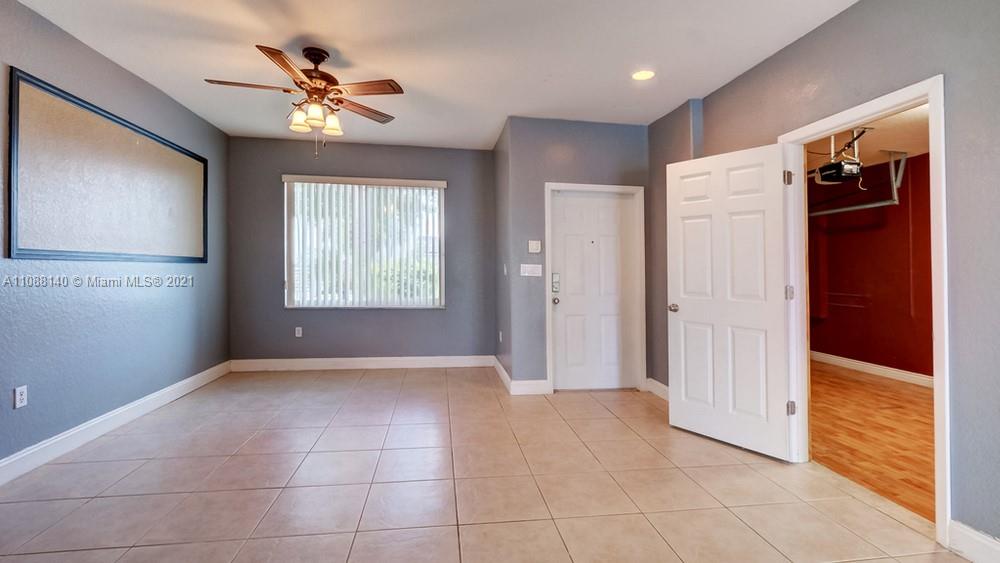 1311 Southeast 20th Road, Unit 1311 Homestead, FL 33035 - Photo 5 of 40 an empty room with chandelier fan and windows