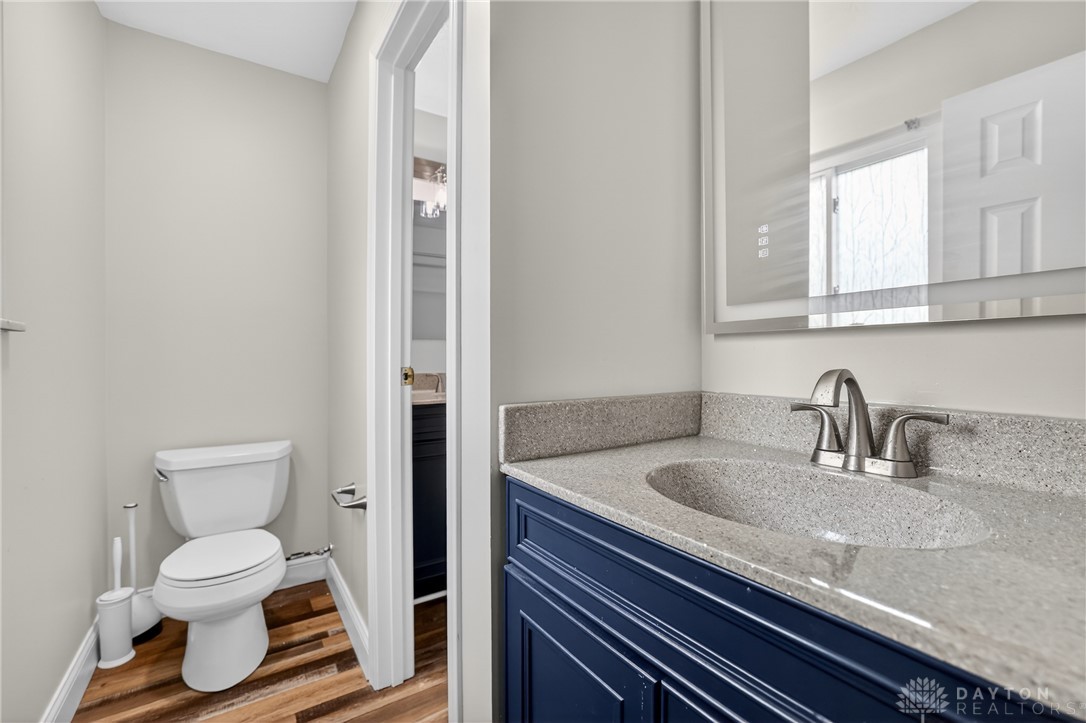 5741 Gray Road Fairfield, OH 45014 - Photo 23 of 32 This bright bathroom features a blue vanity with a modern sink and a toilet with wood flooring.