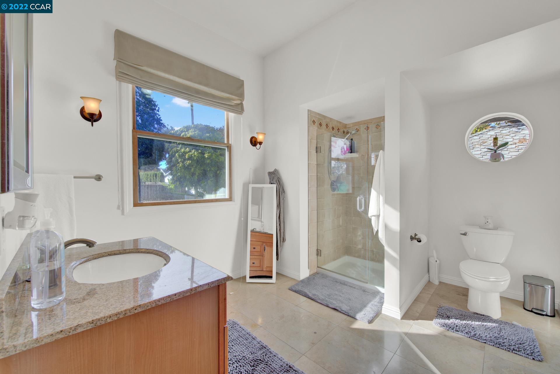 2004 Main Street Napa, CA 94559 - Photo 7 of 7 a bathroom with a granite countertop sink a mirror and a shower