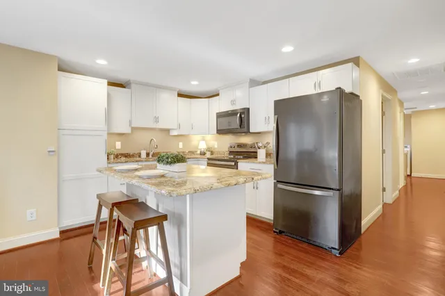 a kitchen with stainless steel appliances granite countertop a refrigerator and a stove top oven