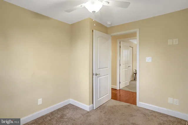 an empty room with wooden floor and a bathroom