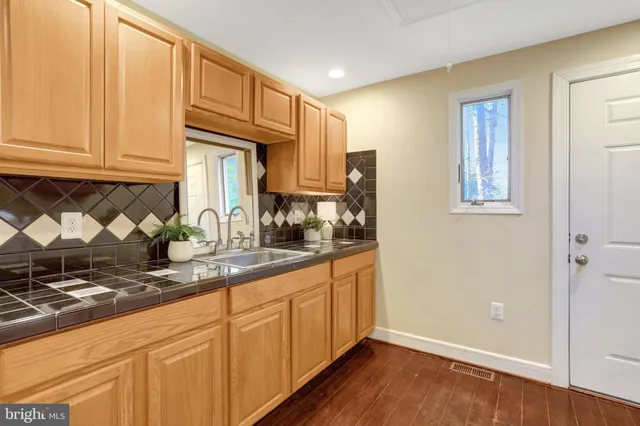 a kitchen with granite countertop wooden cabinets and a sink