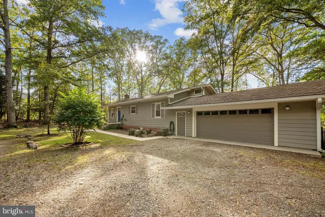 a view of a house with garden and trees