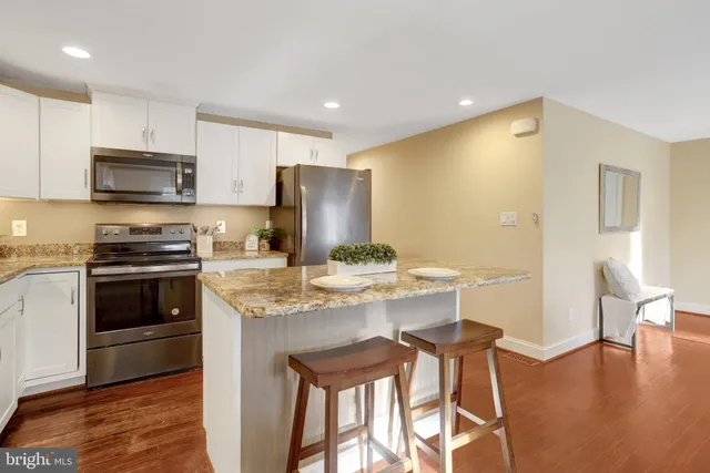 a kitchen with stainless steel appliances a stove a sink refrigerator and microwave