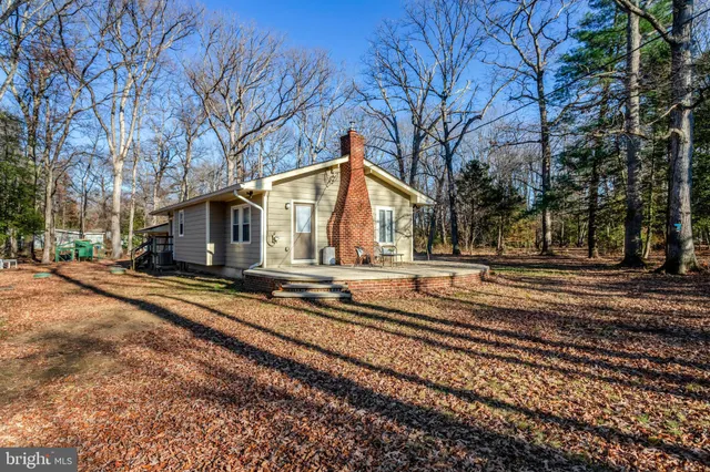 a view of a house with backyard and trees
