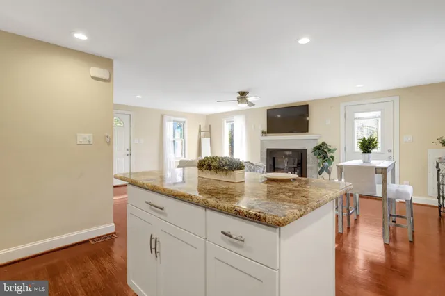 a kitchen with granite countertop a stove and a wooden floor