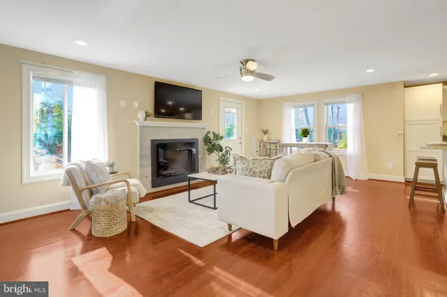 a living room with furniture a flat screen tv and a fireplace