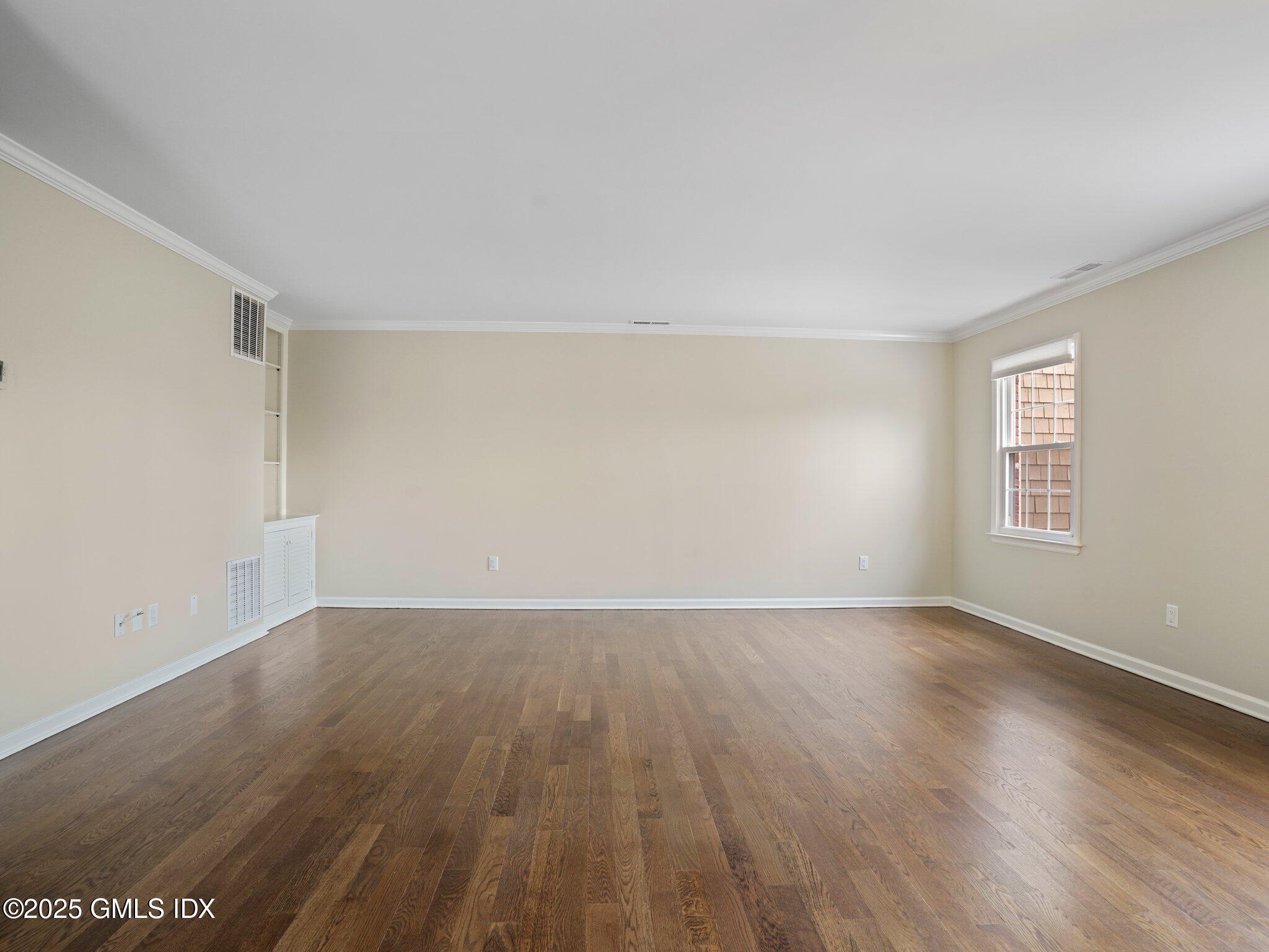 102 Valley Road, Unit 23 Cos Cob, CT 06807 - Photo 8 of 13 a view of an empty room with wooden floor and a window