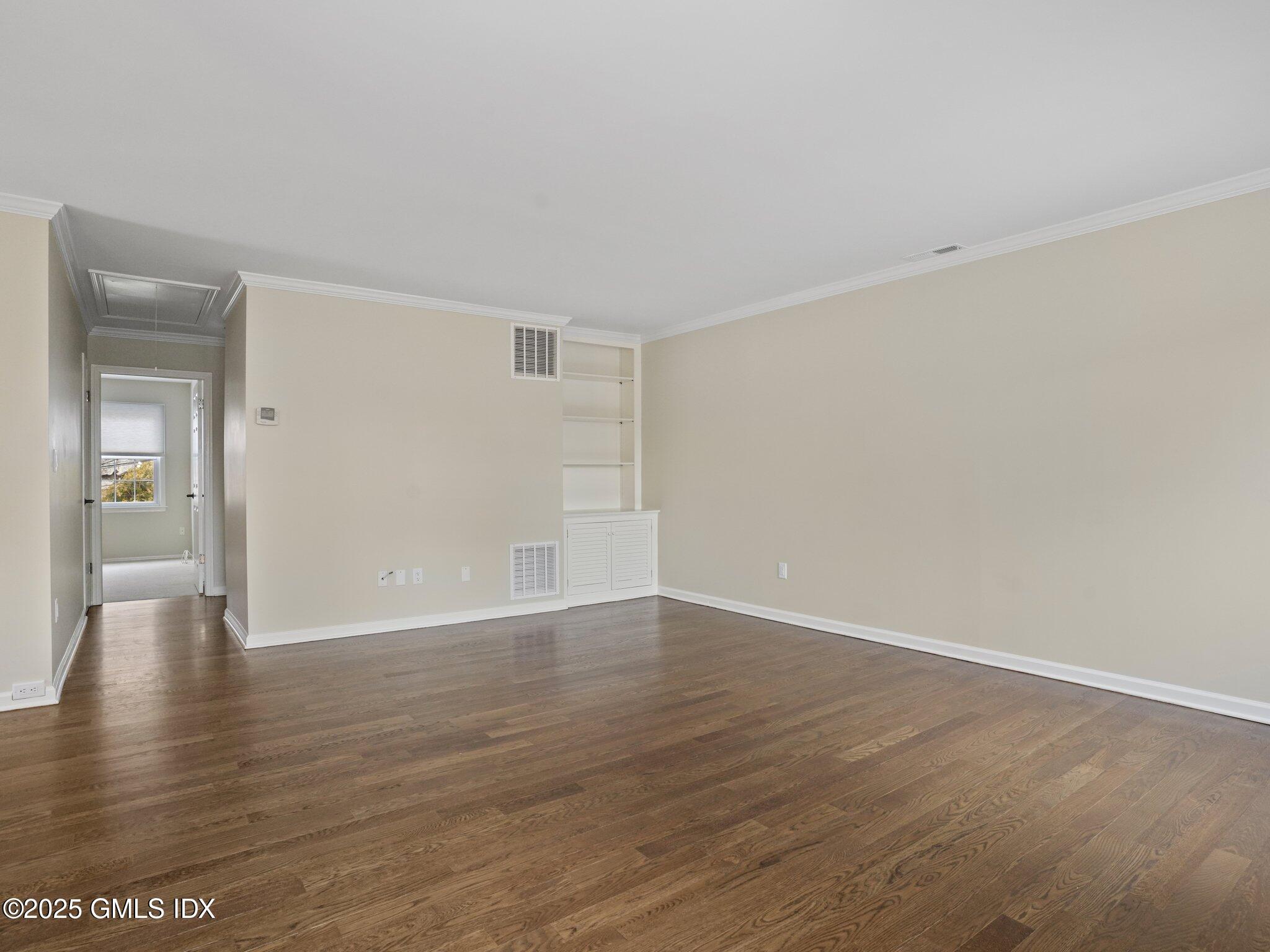 102 Valley Road, Unit 23 Cos Cob, CT 06807 - Photo 9 of 13 a view of an empty room with wooden floor and a window
