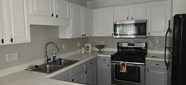 a kitchen with stainless steel appliances granite countertop a sink stove refrigerator and cabinets