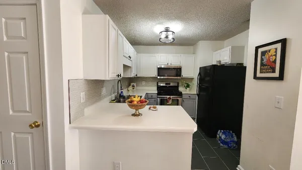 a kitchen with stainless steel appliances a refrigerator sink and cabinets