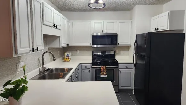 a kitchen with stainless steel appliances a refrigerator a sink a stove a microwave and cabinets