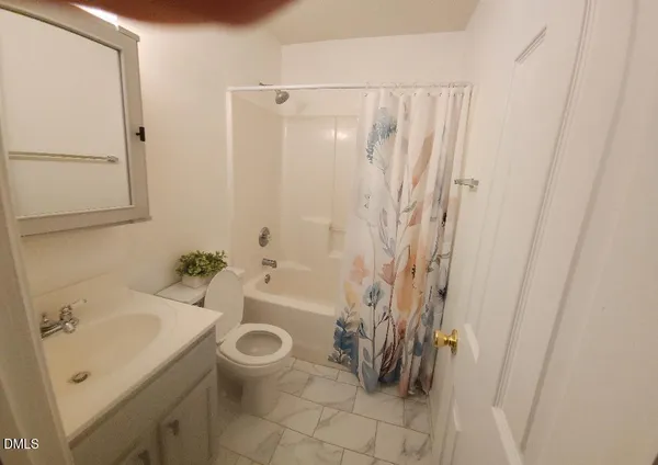 a bathroom with a sink a toilet and shower curtain