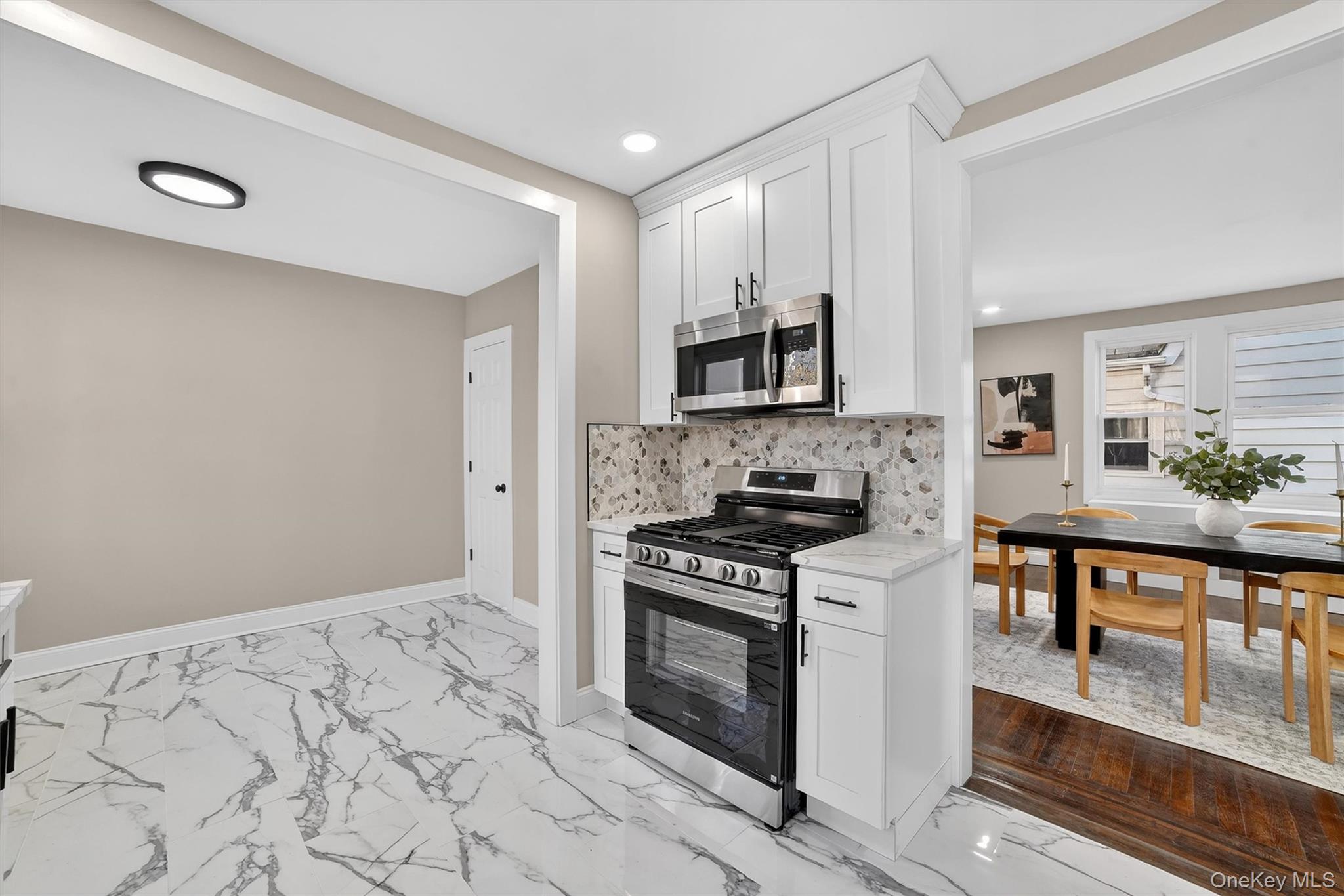 94 Jervis Road Yonkers, NY 10705 - Photo 18 of 50 a kitchen with stainless steel appliances a stove a microwave a sink and white cabinets