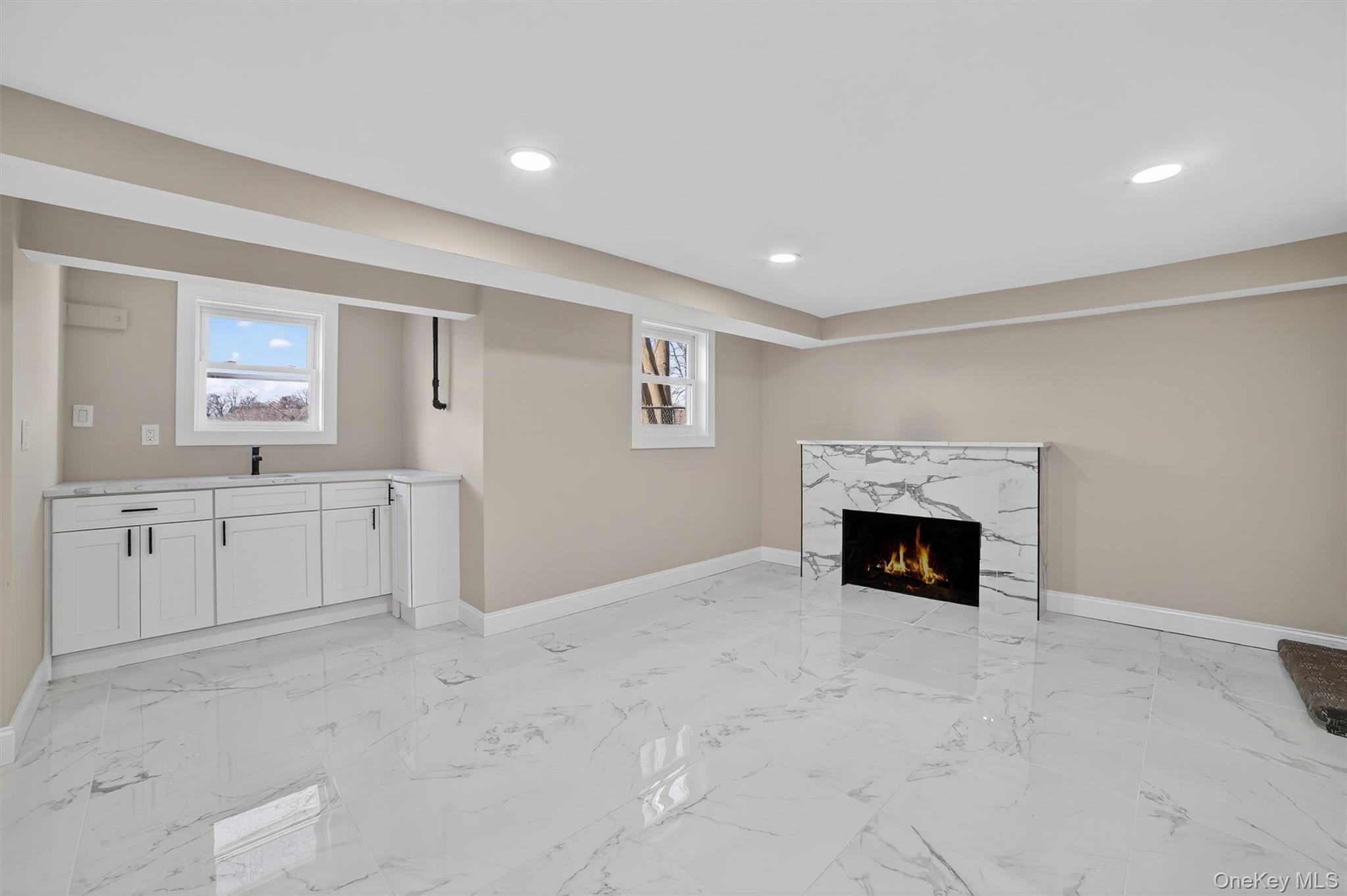 94 Jervis Road Yonkers, NY 10705 - Photo 44 of 50 a large white kitchen with a sink and dishwasher a fireplace with wooden floor