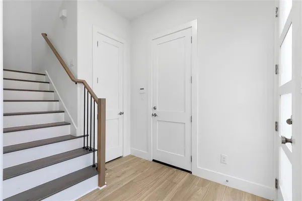 a view of a hallway with wooden floor and entryway