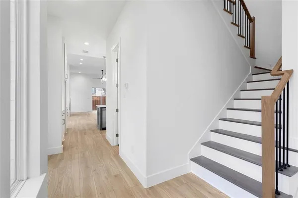 a view of a hallway with wooden floor and entryway