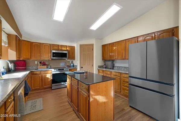 a kitchen with stainless steel appliances granite countertop a refrigerator stove microwave and sink