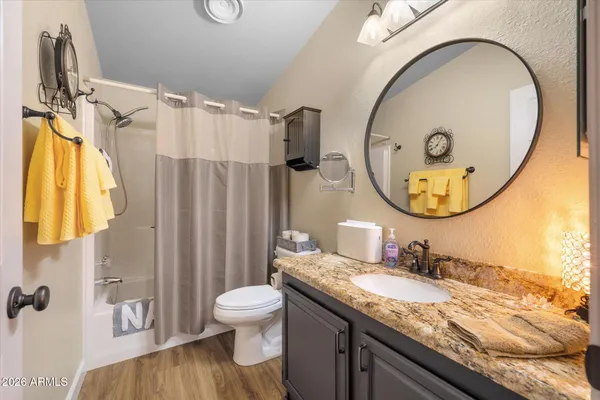 a bathroom with a granite countertop sink mirror vanity and a toilet