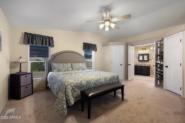 a spacious bedroom with a bed and a chandelier