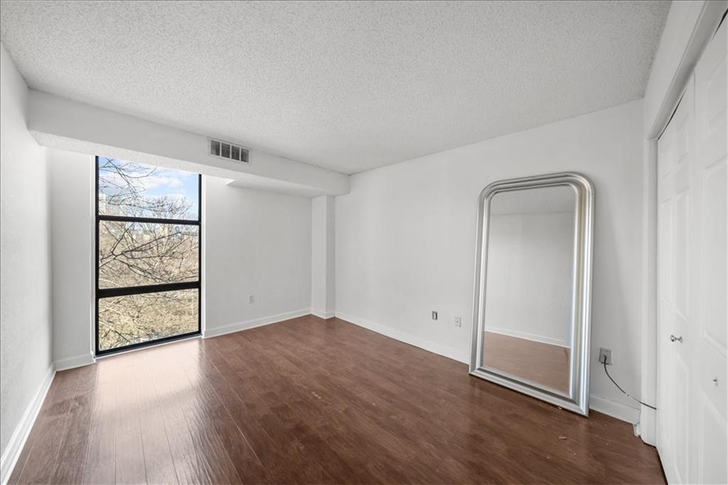 375 Ralph McGill Boulevard Northeast, Unit 407 Atlanta, GA 30312 - Photo 14 of 22 an empty room with wooden floor closet and windows