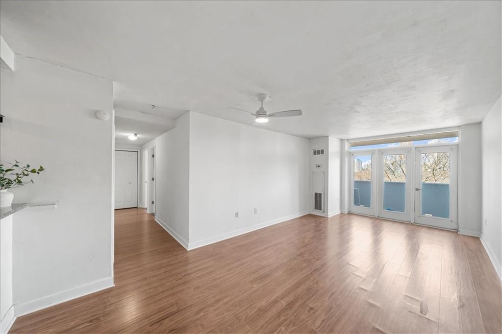 375 Ralph McGill Boulevard Northeast, Unit 407 Atlanta, GA 30312 - Photo 8 of 22 a view of an empty room with wooden floor and a window