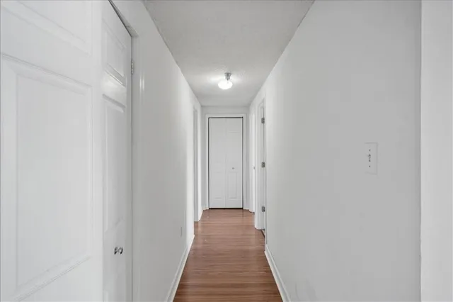 a view of a hallway with wooden floor