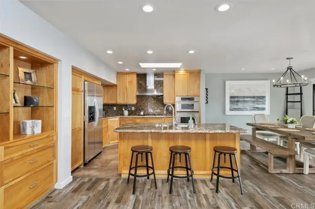 a kitchen with stainless steel appliances granite countertop wooden floor window and cabinets