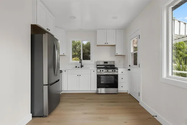 a kitchen with stainless steel appliances a refrigerator stove and sink
