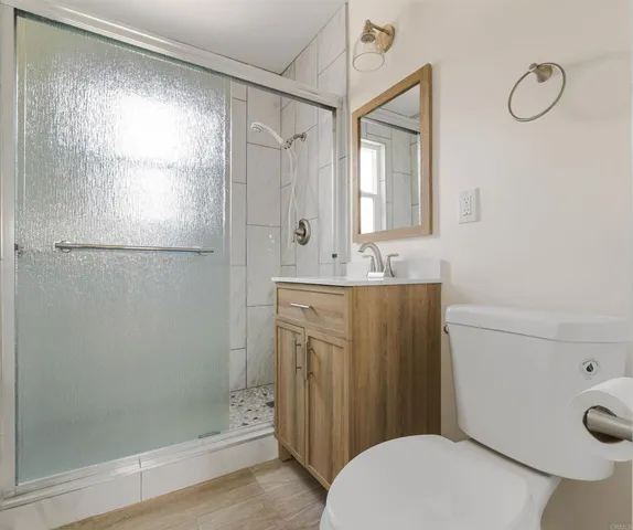 a bathroom with a sink a mirror a toilet and shower